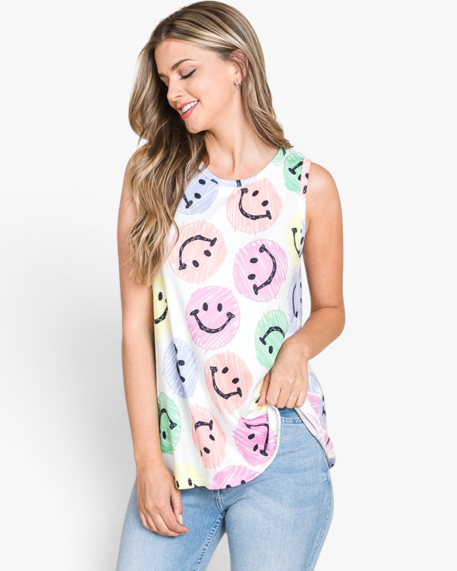 A woman wearing a sleeveless white top with a colorful smiley face pattern, paired with light blue jeans, against a plain white background.