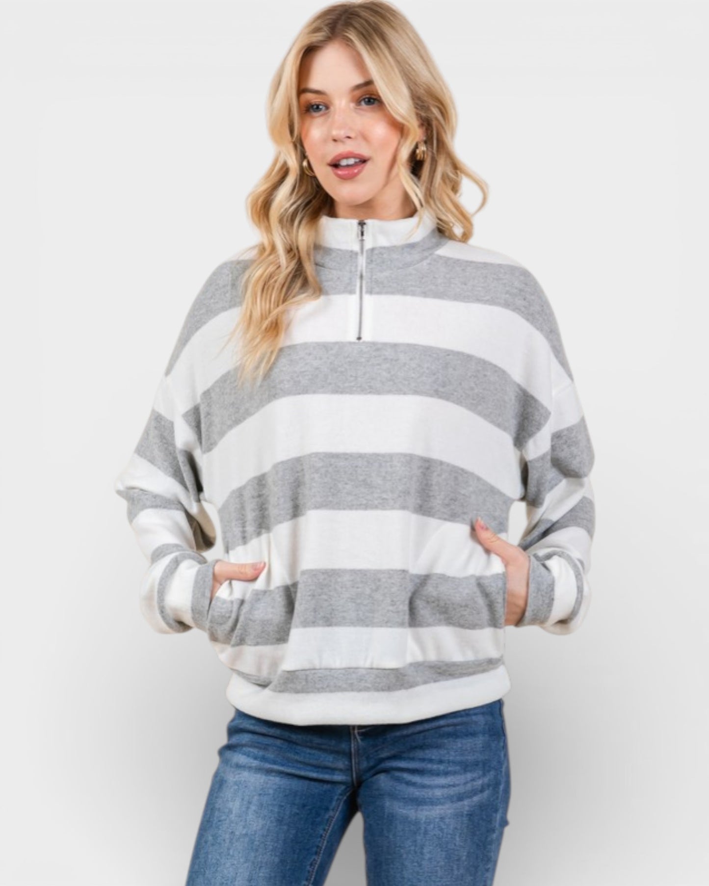 Woman wearing a gray and white striped sweater on a white background