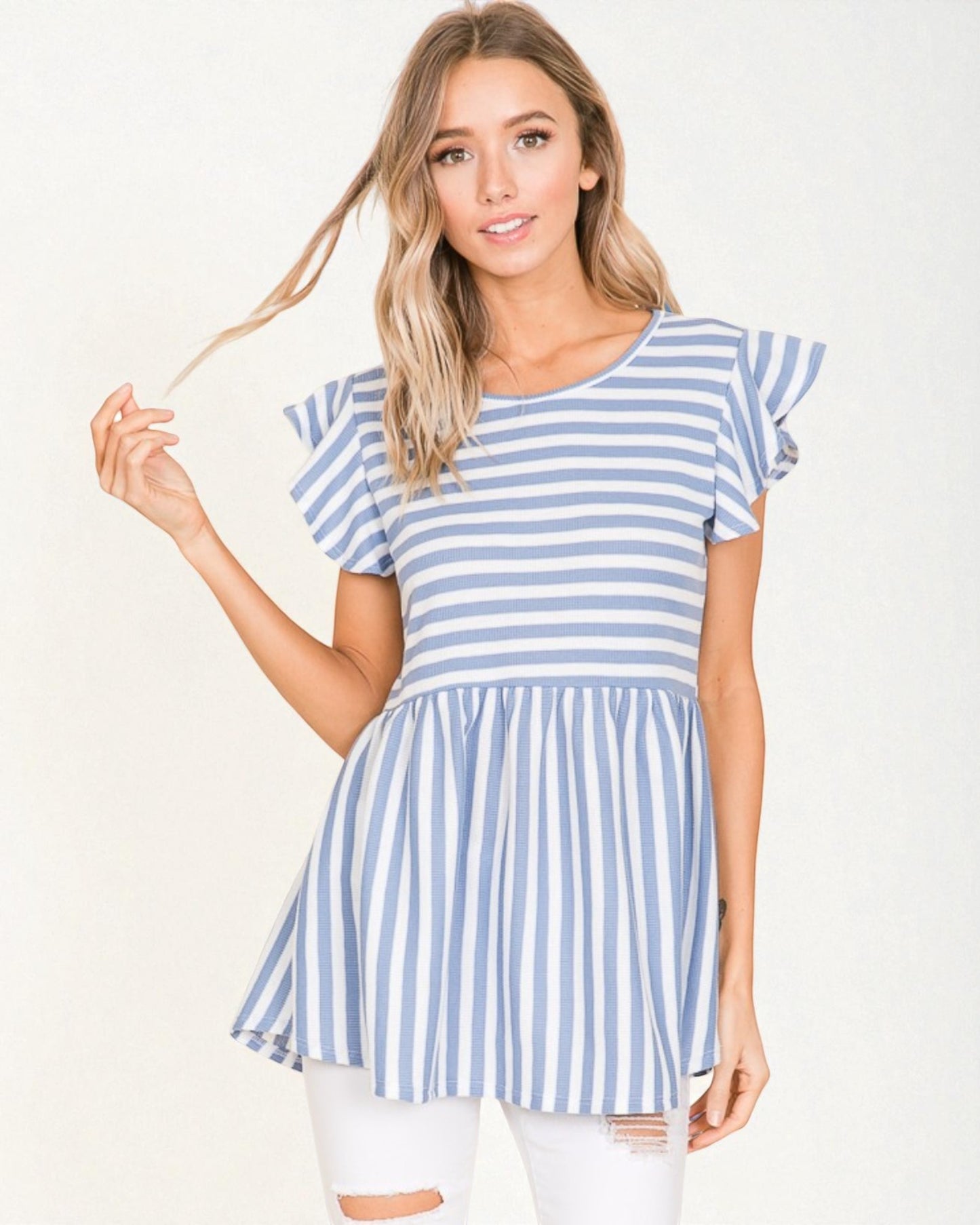 Woman wearing a blue and white striped dress against a white background
