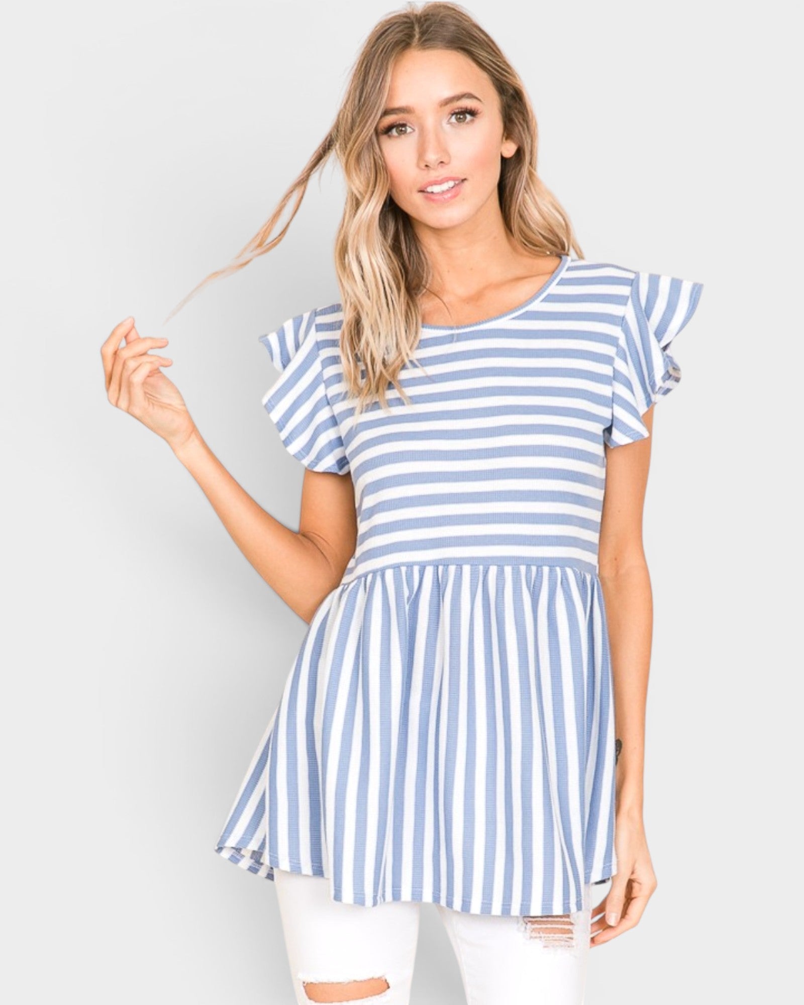 Woman wearing a blue and white striped dress against a plain background