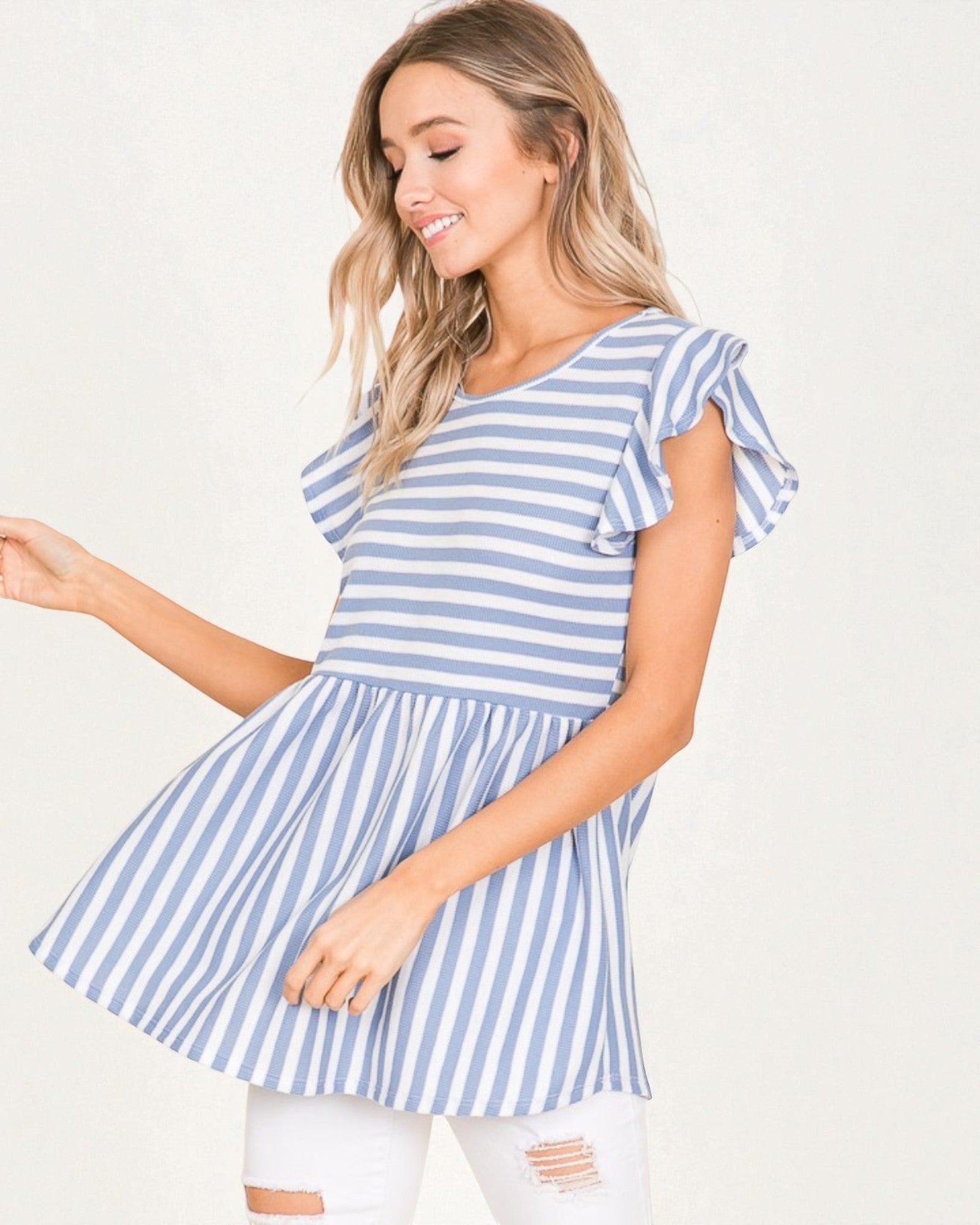 Woman wearing a blue and white striped dress on a plain background