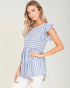 Woman wearing a blue and white striped dress against a plain background