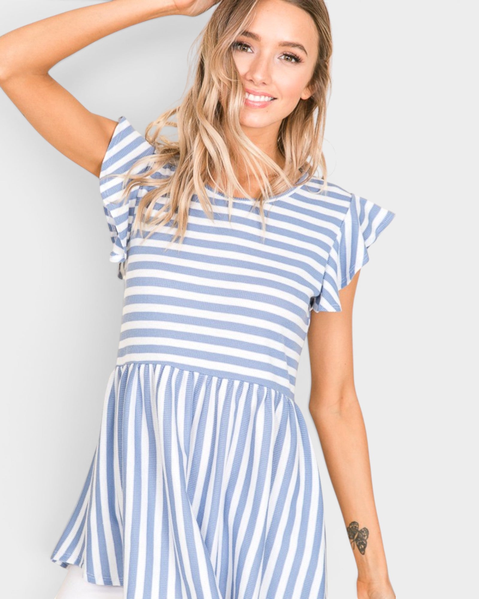 Woman wearing a blue and white striped dress against a plain background