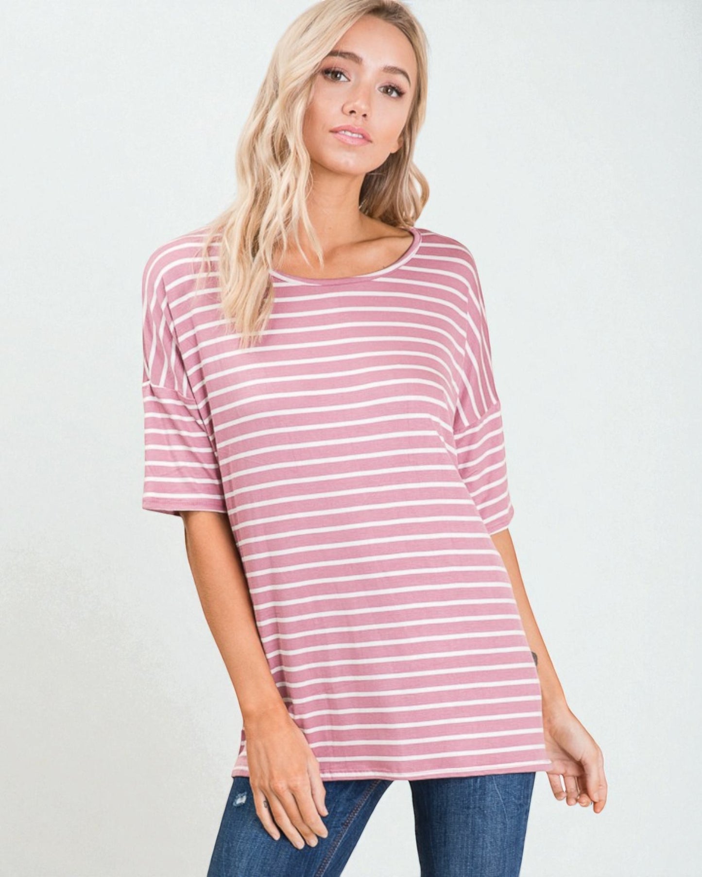 Woman wearing a pink and white striped shirt against a plain background