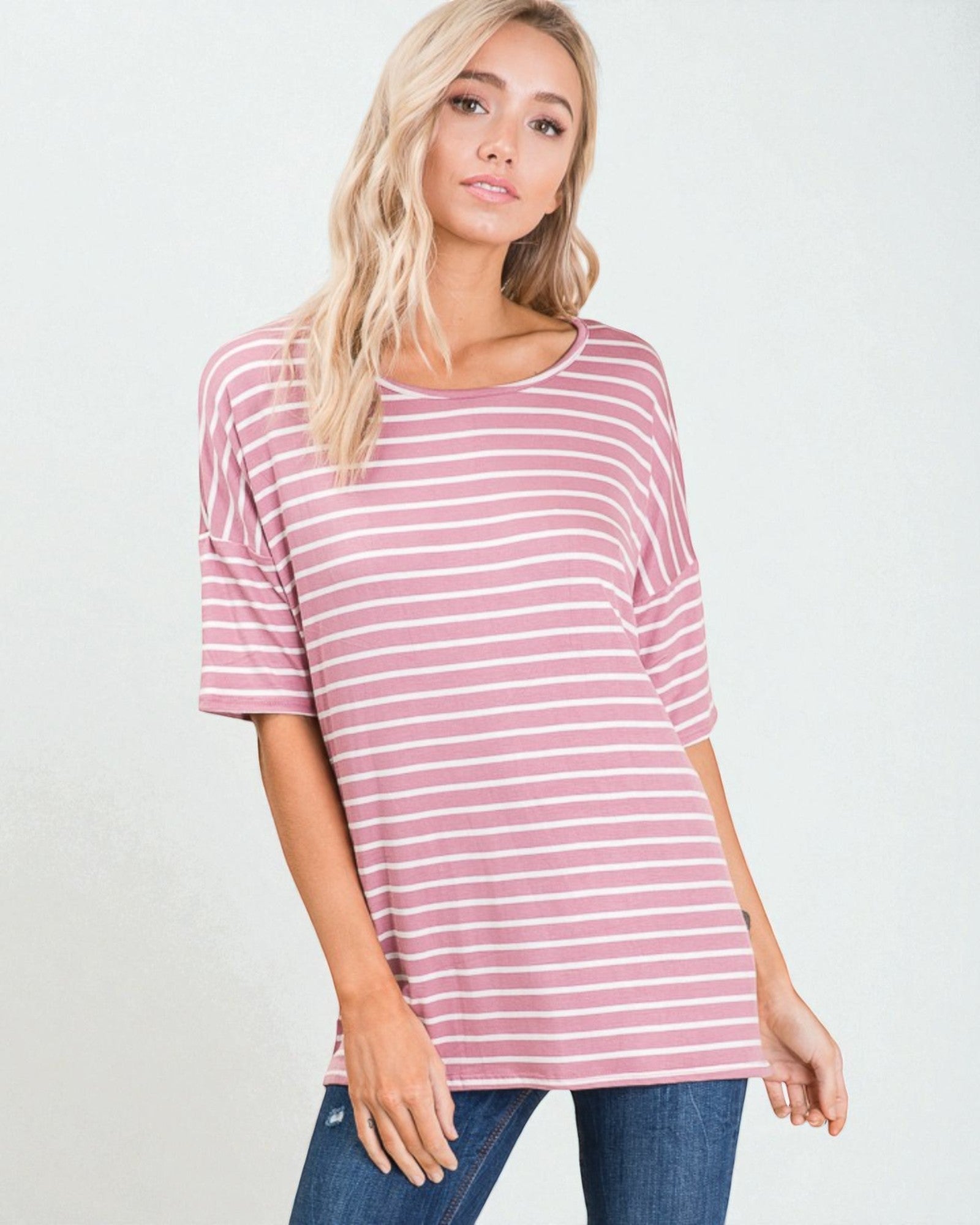 Woman wearing a pink and white striped shirt against a plain background