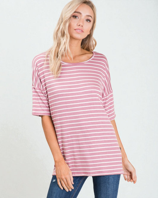 Woman wearing a pink and white striped shirt against a plain background