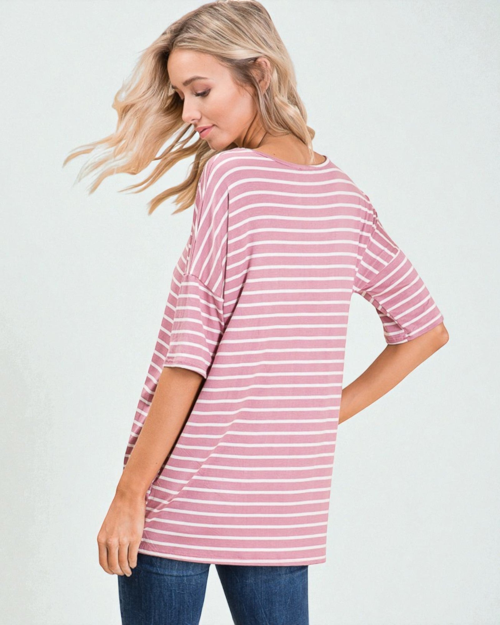 Woman wearing a pink and white striped shirt against a plain background