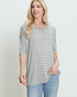 Woman wearing a gray and white striped shirt with a plain background