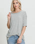 Woman wearing a gray and white striped shirt with a plain background