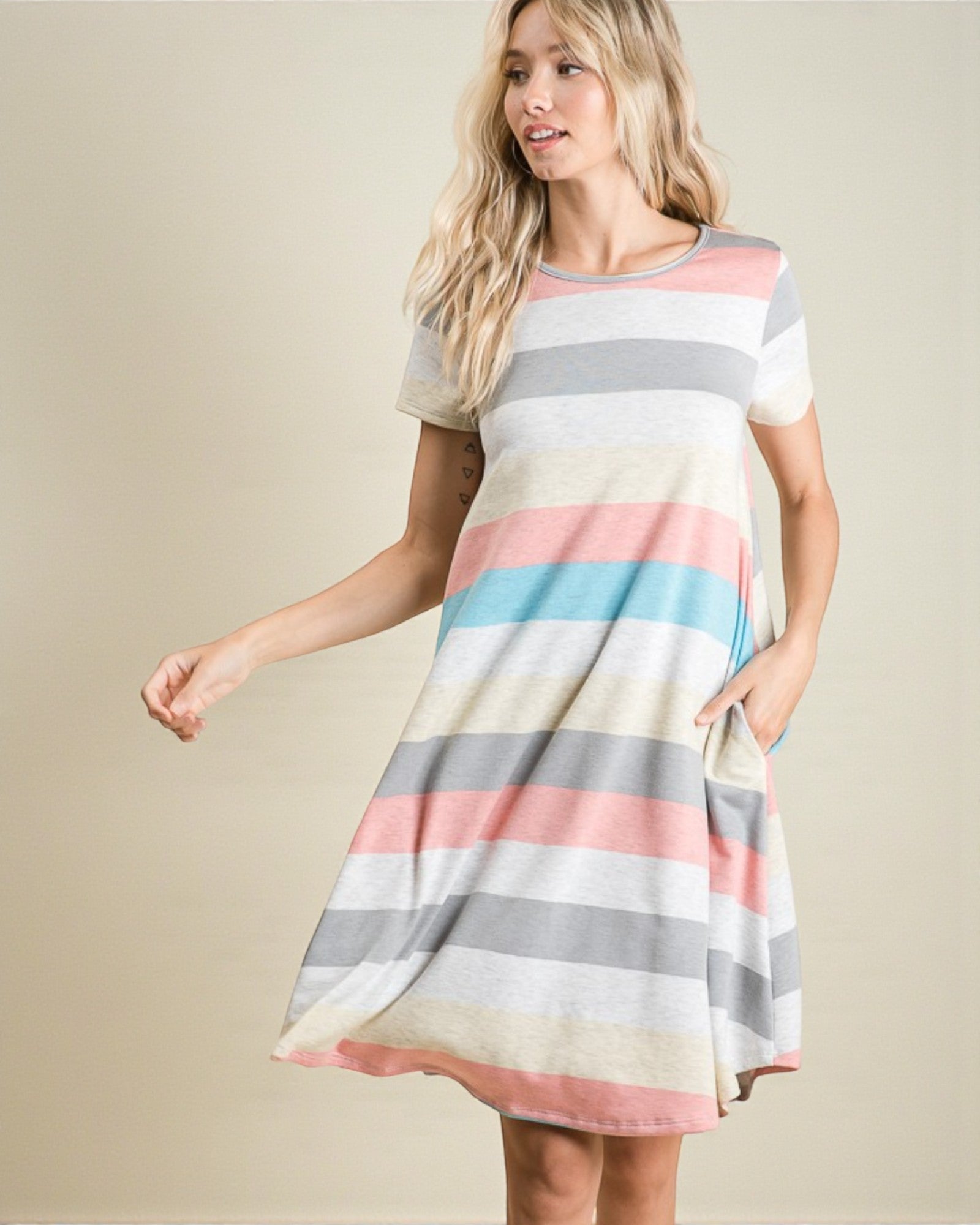 Woman wearing a colorful striped dress on a beige background