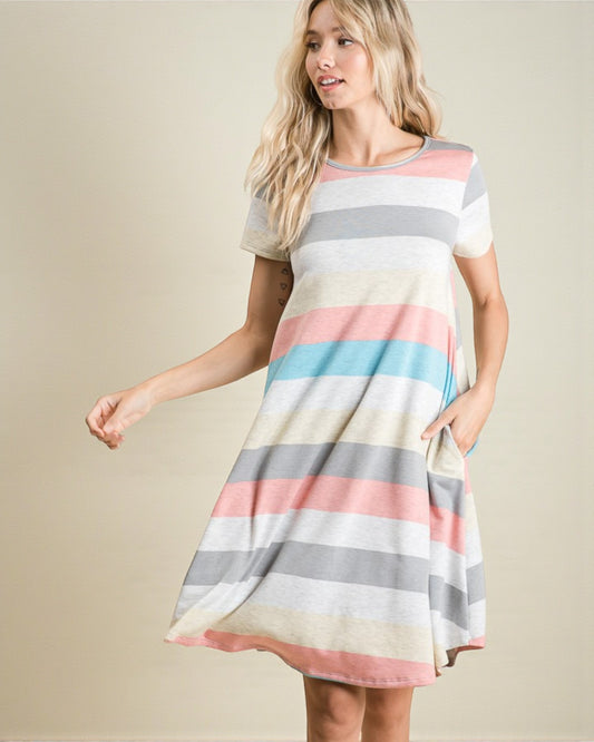 Woman wearing a colorful striped dress on a beige background
