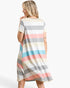 A woman wearing a short-sleeve, A-line shift dress with horizontal pastel stripes in cream, gray, pink, and light blue, shown from a back-three-quarter view against a plain white studio background.