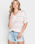 Woman wearing a striped sweater and denim shorts against a white background
