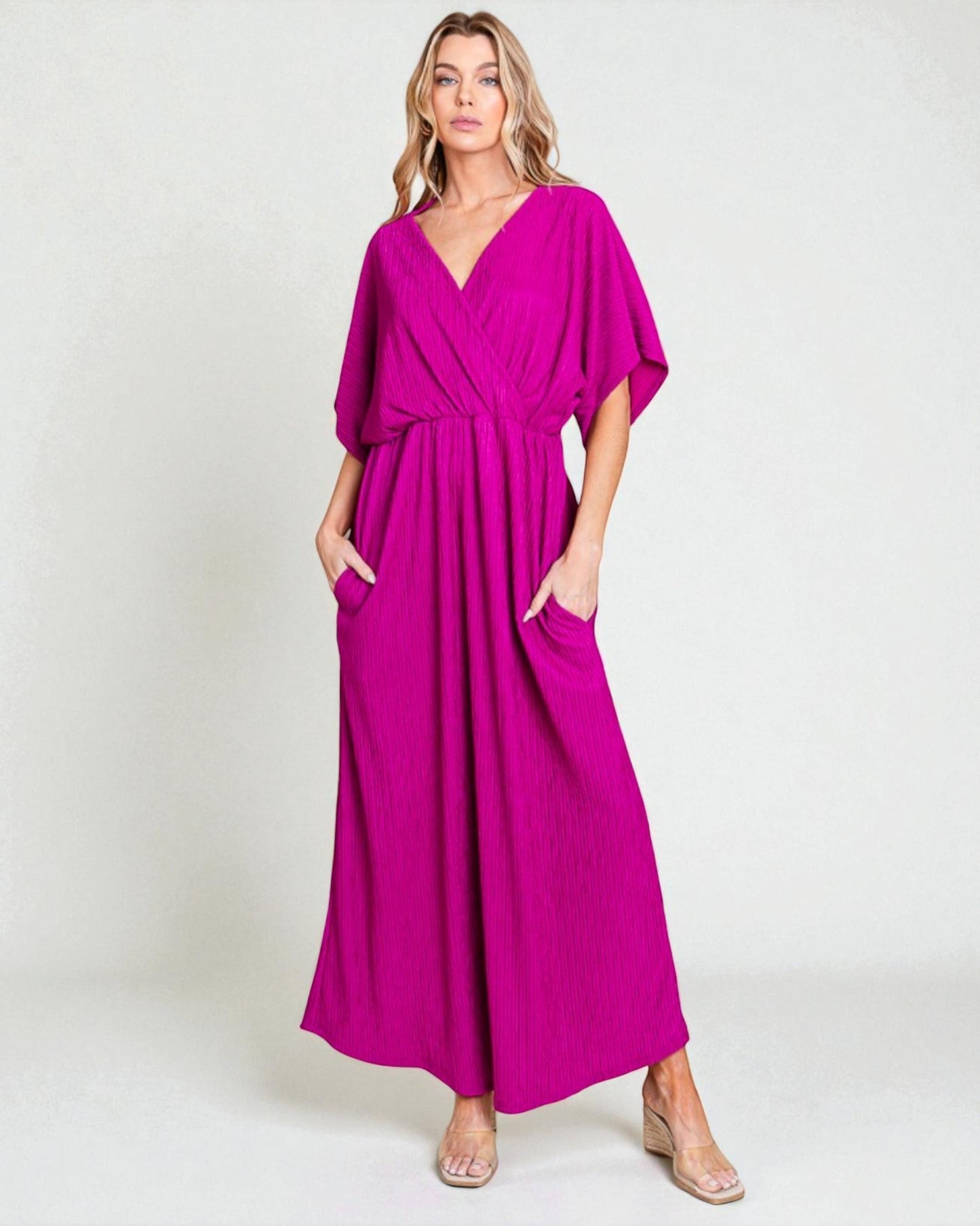 Woman wearing a magenta dress with a plain background