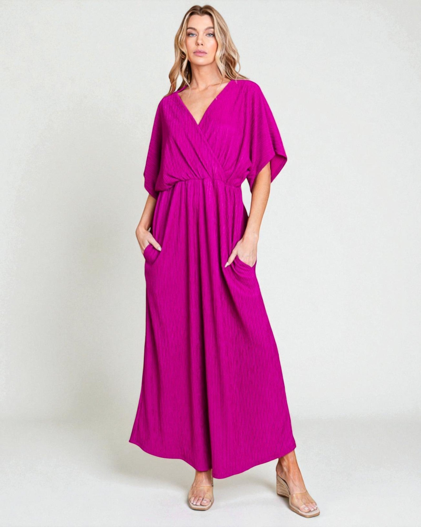 Woman wearing a magenta dress with a plain background