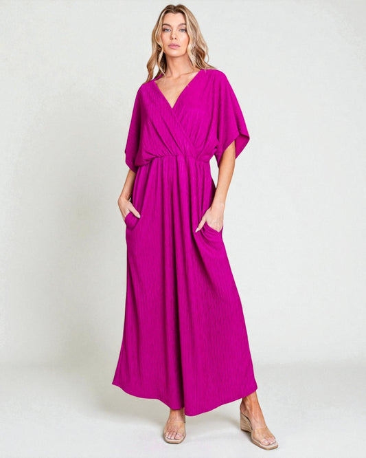 Woman wearing a magenta dress with a plain background