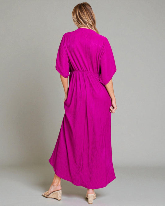 Woman wearing a bright pink dress against a plain background