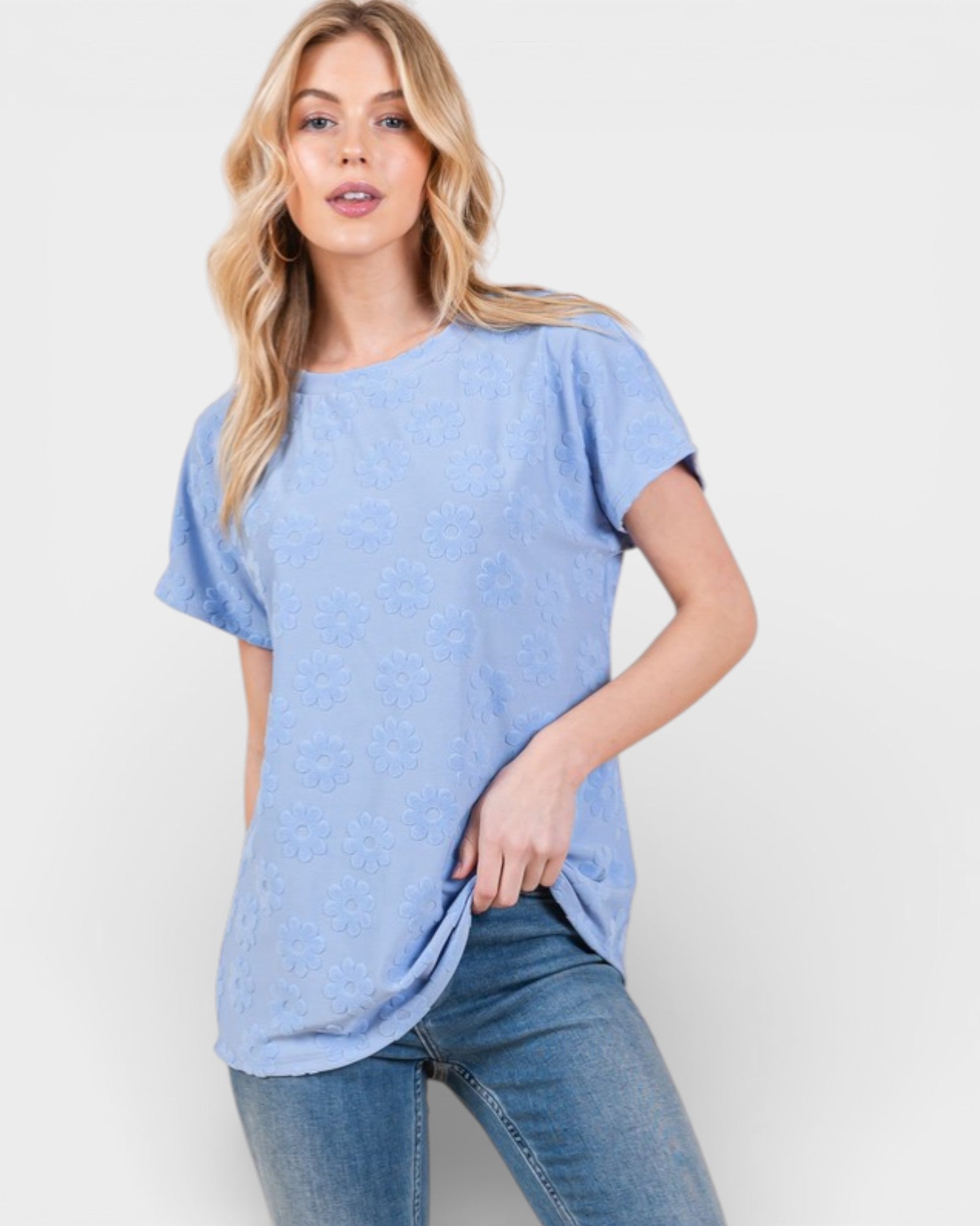 Woman wearing a light blue t-shirt and jeans on a white background