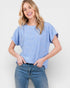 Woman wearing a light blue t-shirt and jeans against a white background