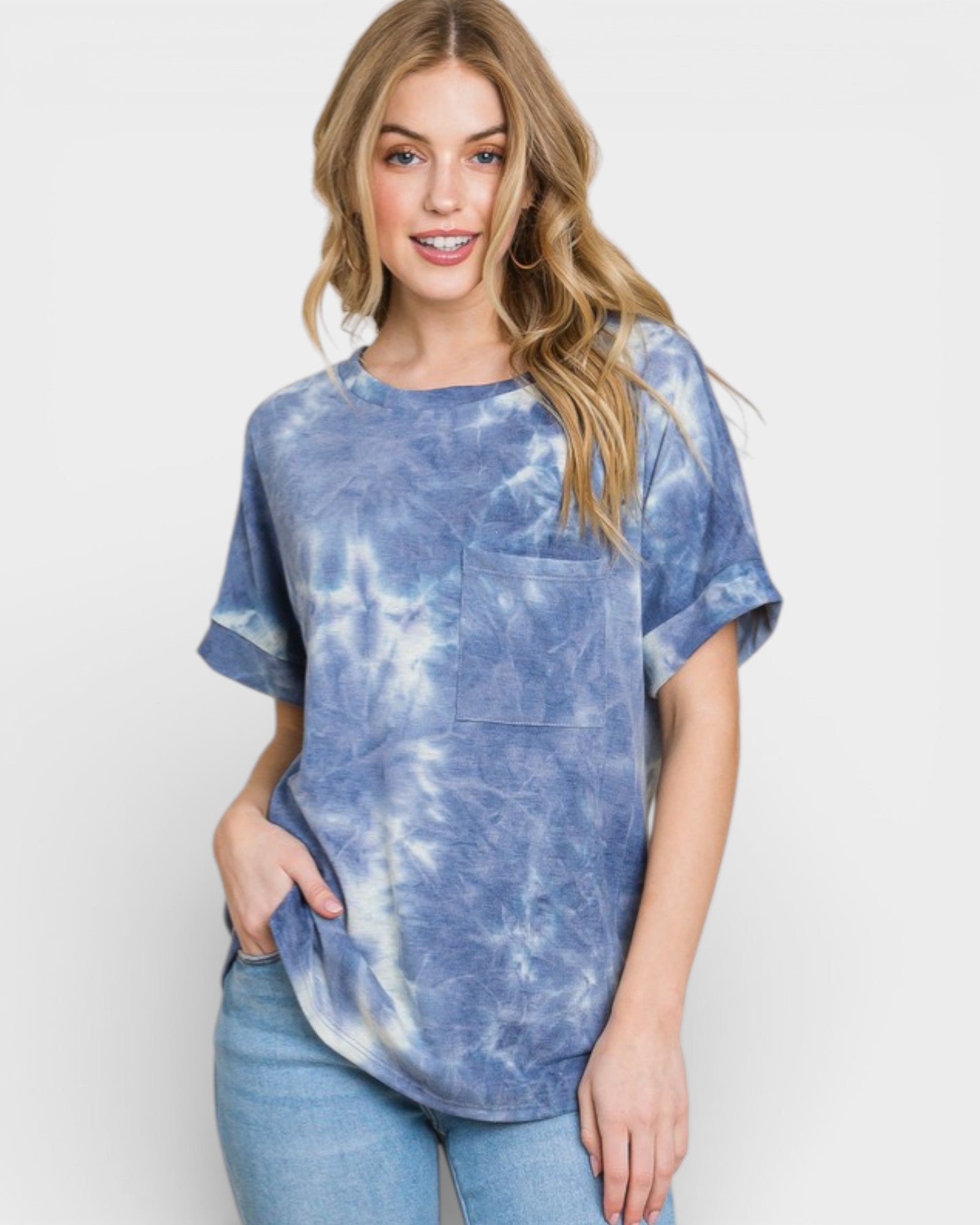 Woman wearing a blue tie-dye shirt with a plain background