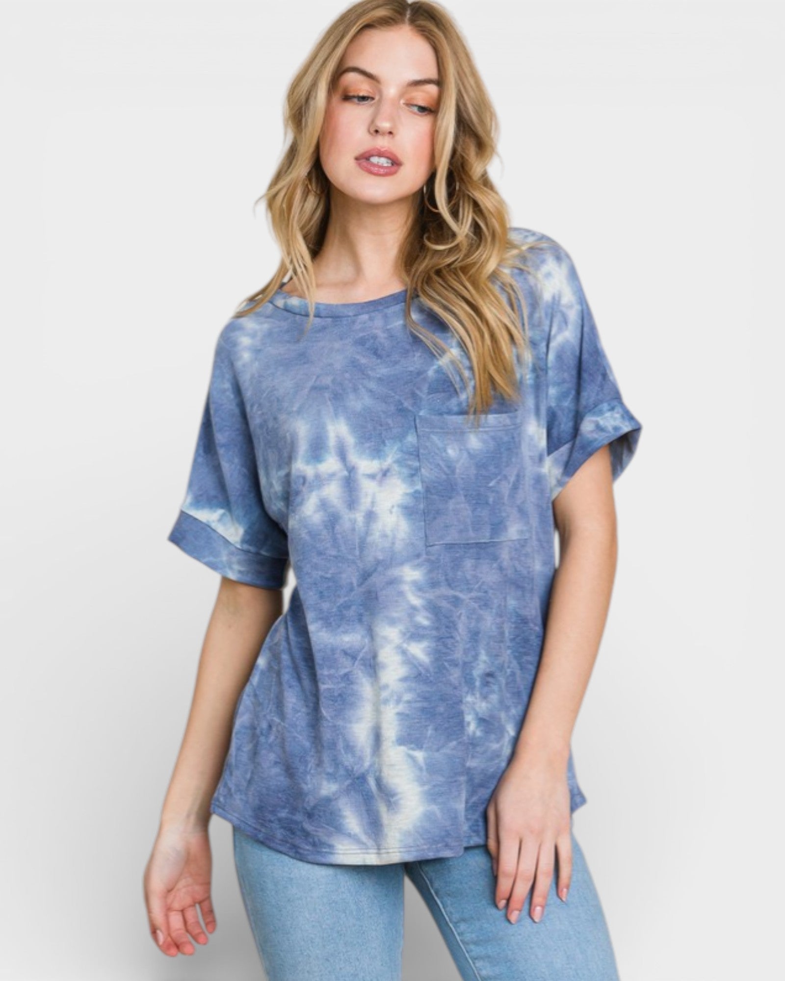Woman wearing a blue tie-dye t-shirt and jeans on a white background