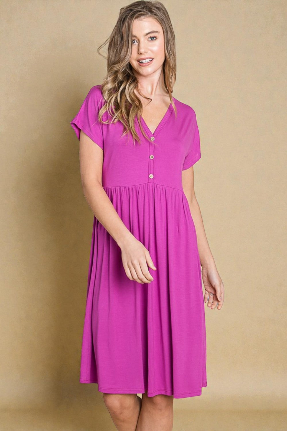 Woman wearing a pink dress against a beige background