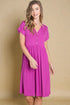 Woman wearing a pink dress against a beige background