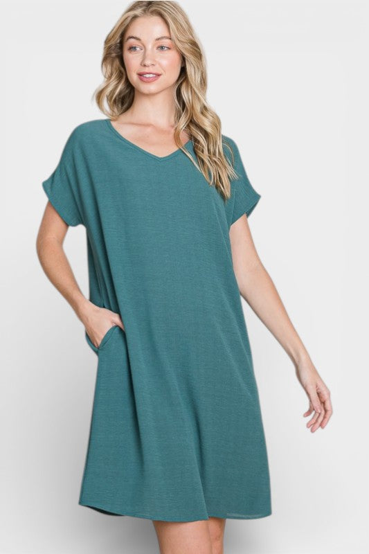 Woman wearing a teal dress on a white background