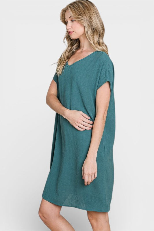Woman wearing a teal dress on a white background