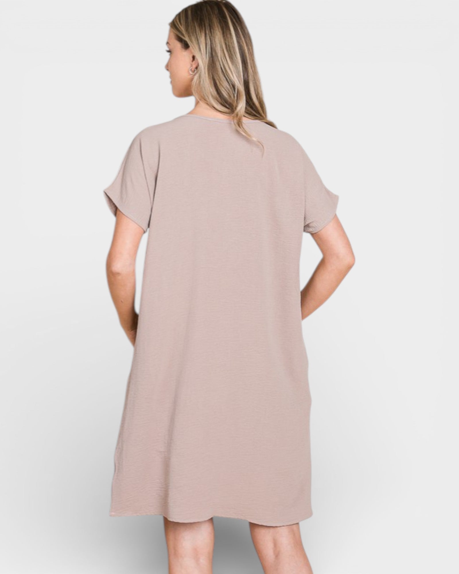 Woman wearing a beige dress on a white background