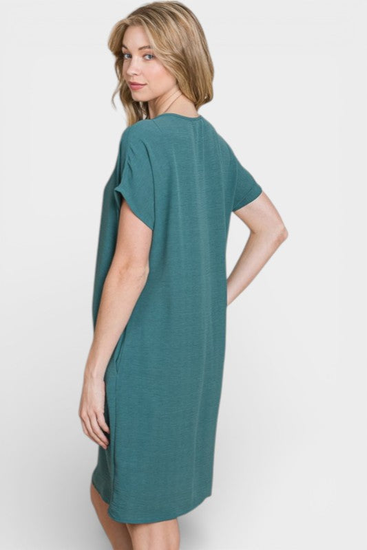 Woman wearing a teal dress on a white background