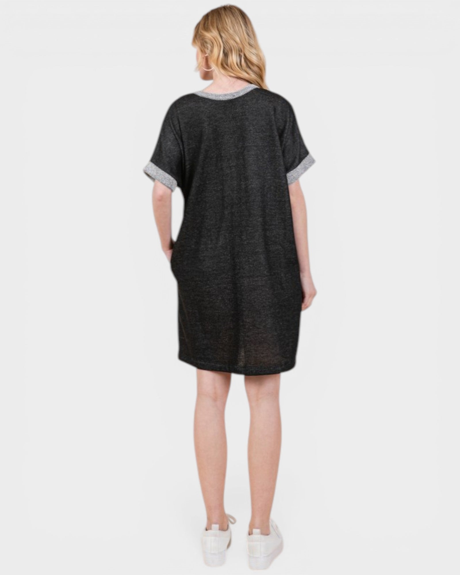 Person wearing a black dress with gray trim on a white background