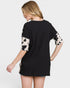 Woman wearing a black t-shirt with cow print sleeves on a white background