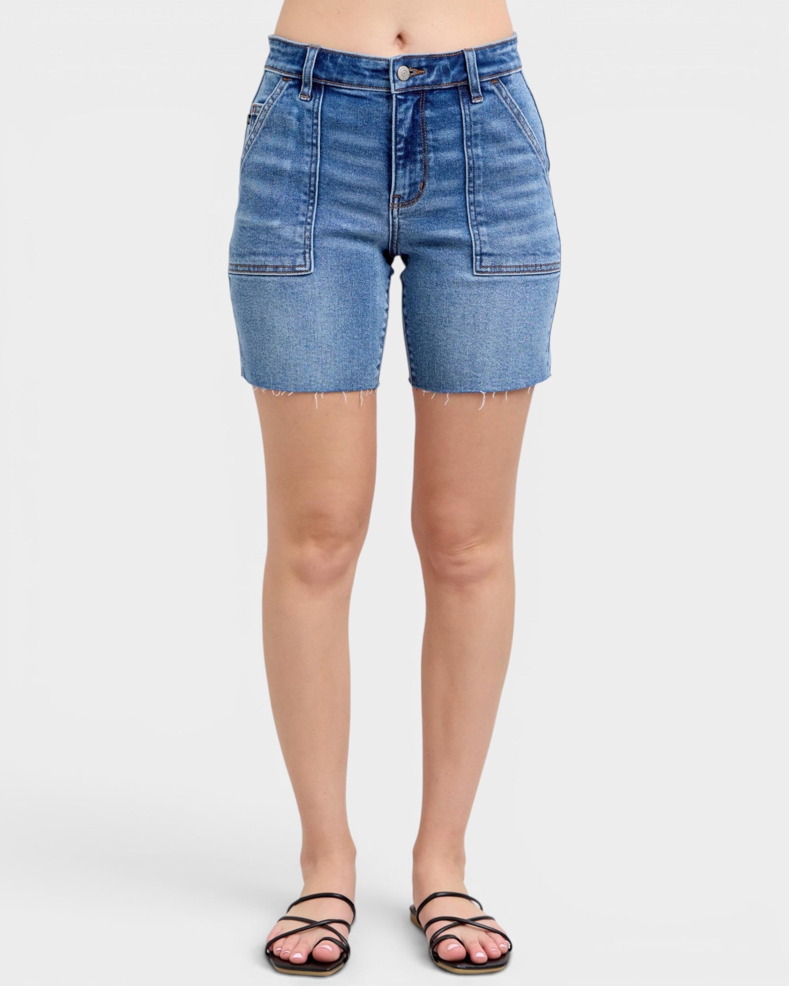 Blue denim shorts worn by a person on a white background