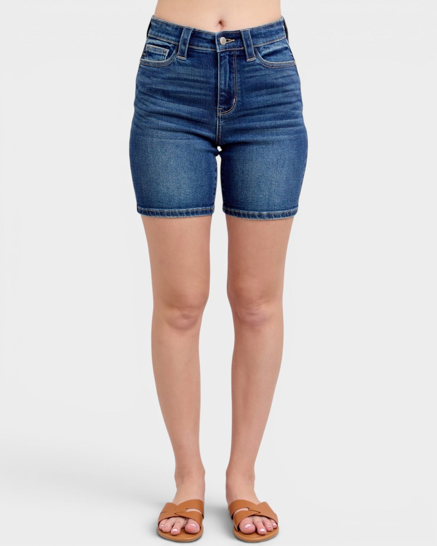 Blue denim shorts worn by a person on a white background