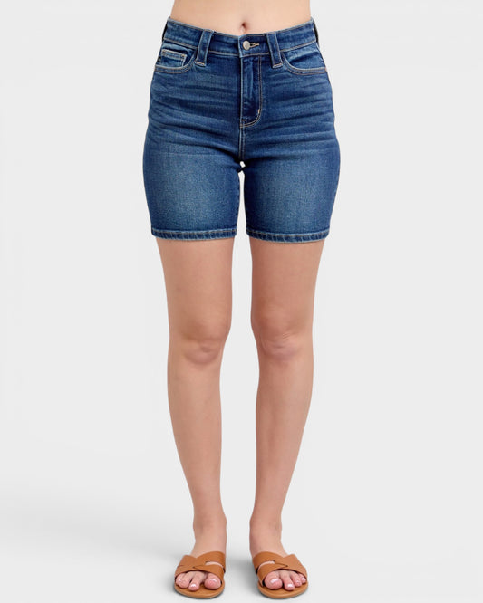 Blue denim shorts worn by a person on a white background