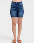 Blue denim shorts worn by a person on a white background
