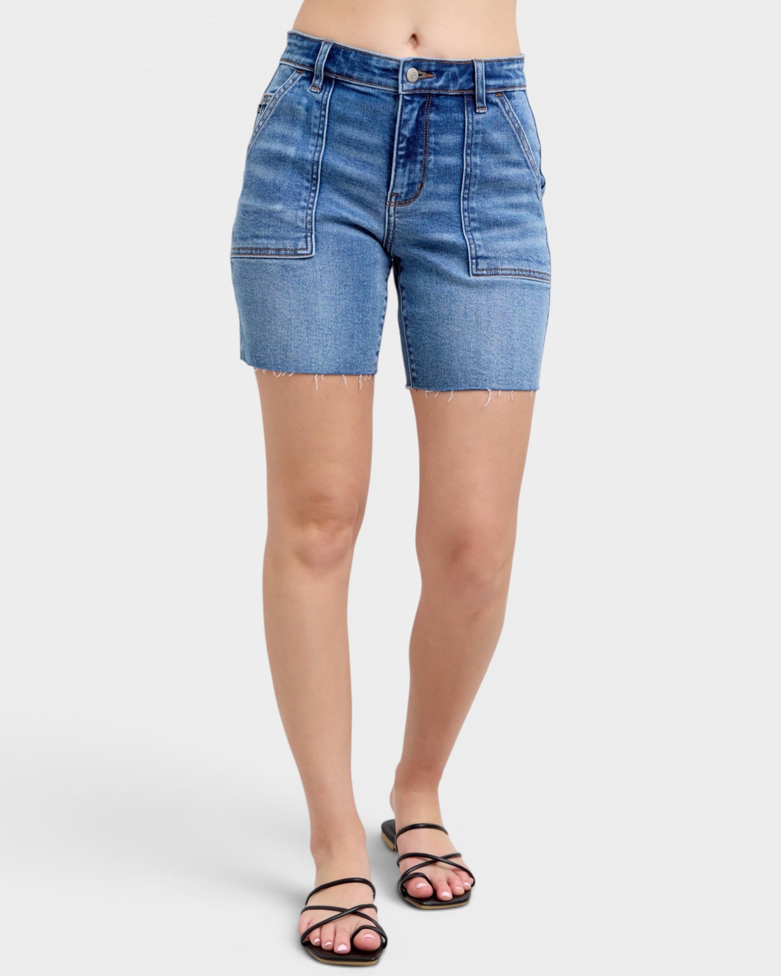 Blue denim shorts worn by a person on a white background