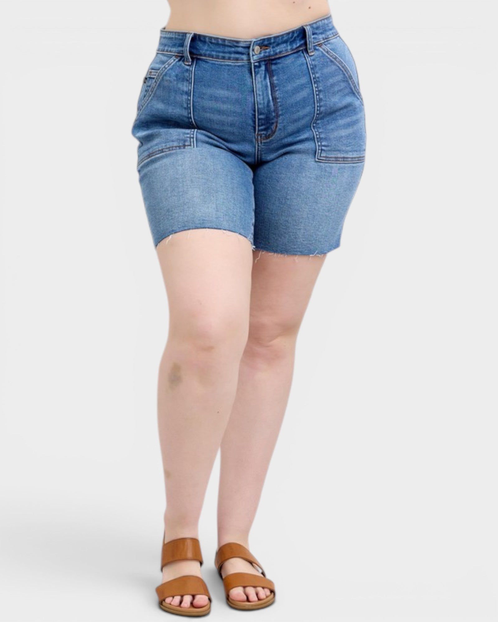Person wearing blue denim shorts on a white background