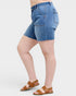 Person wearing blue denim shorts on a white background