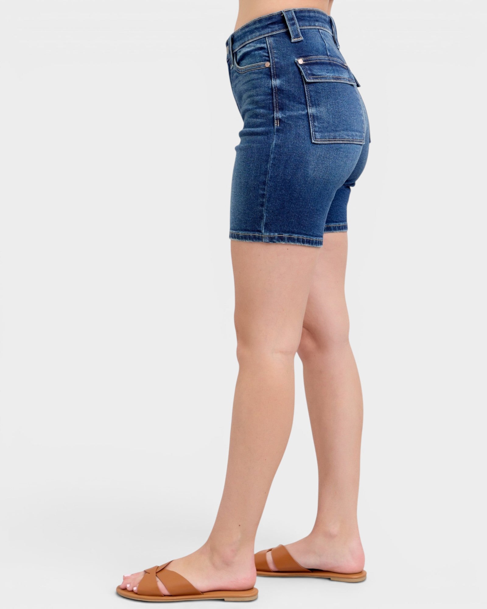 Blue denim shorts worn by a person on a white background