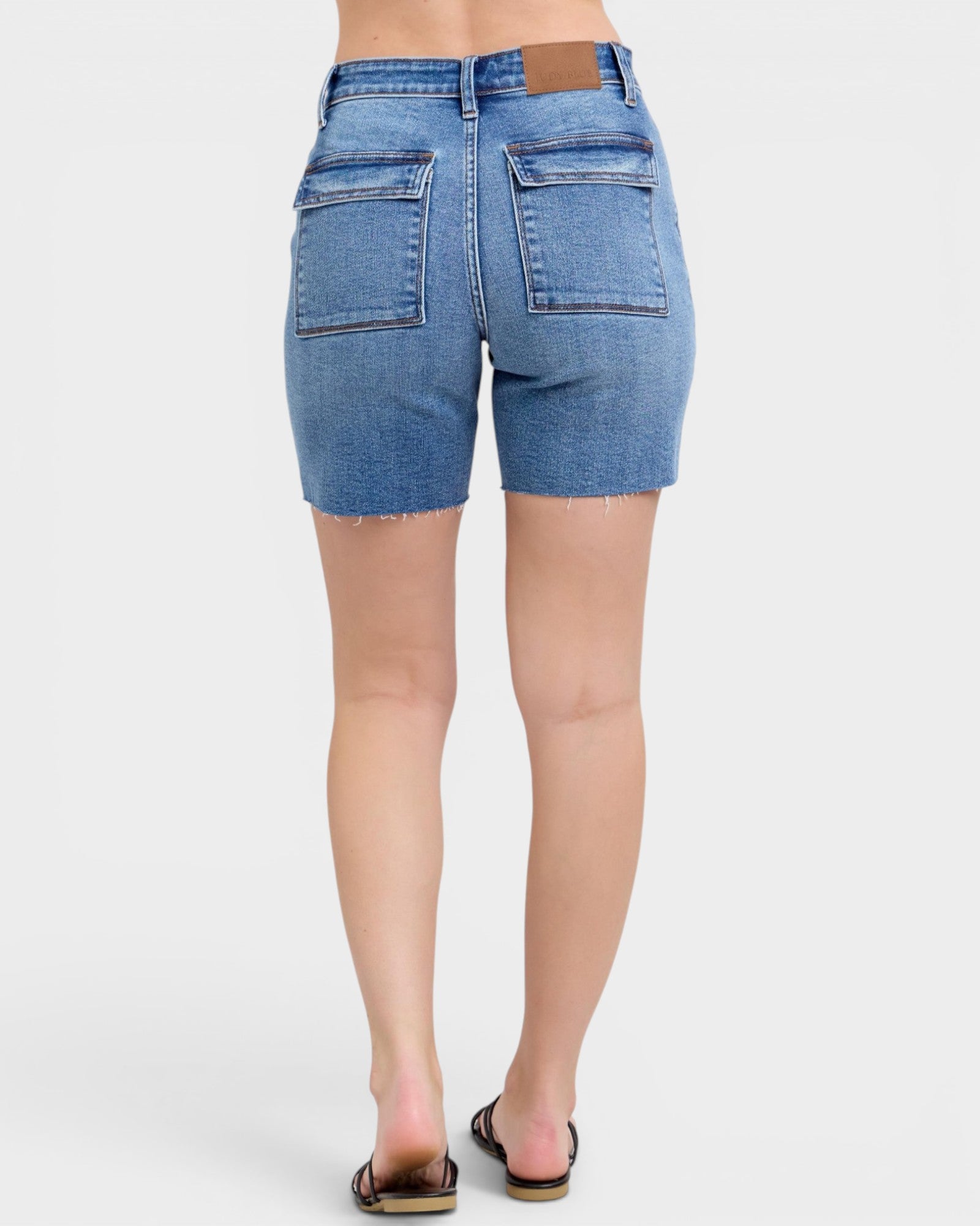Denim shorts worn by a person on a white background