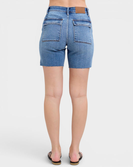 Blue denim shorts worn by a person on a white background