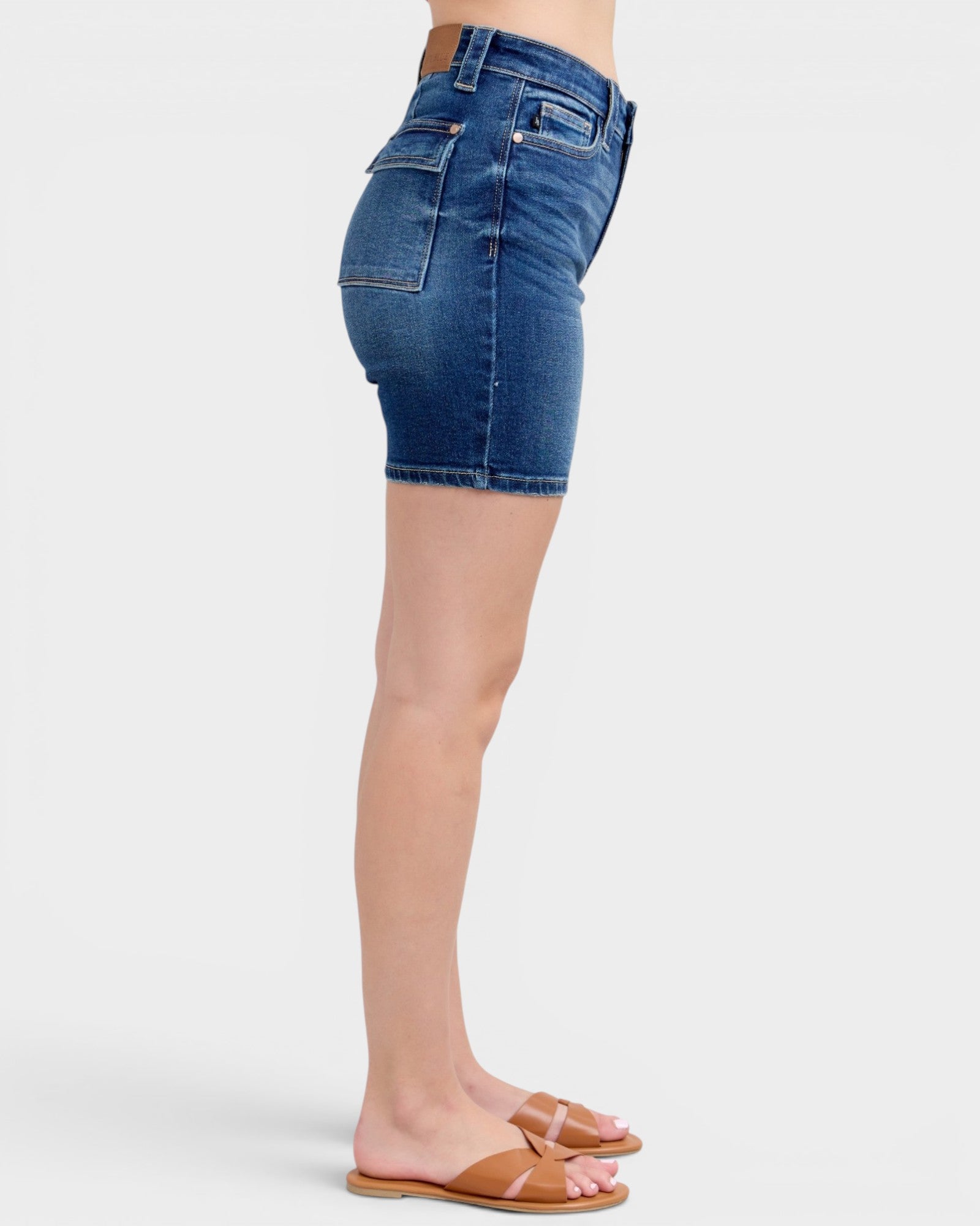 Blue denim shorts worn by a person on a white background