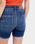 Blue denim shorts worn by a person on a white background