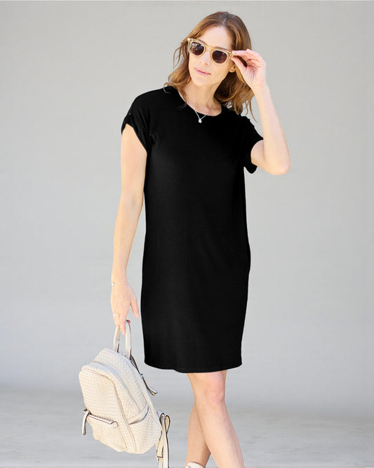 Woman wearing a black dress holding sunglasses and a beige backpack on a gray background