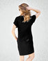 Woman wearing a black dress against a light gray background