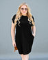 Woman wearing a black dress against a gray background