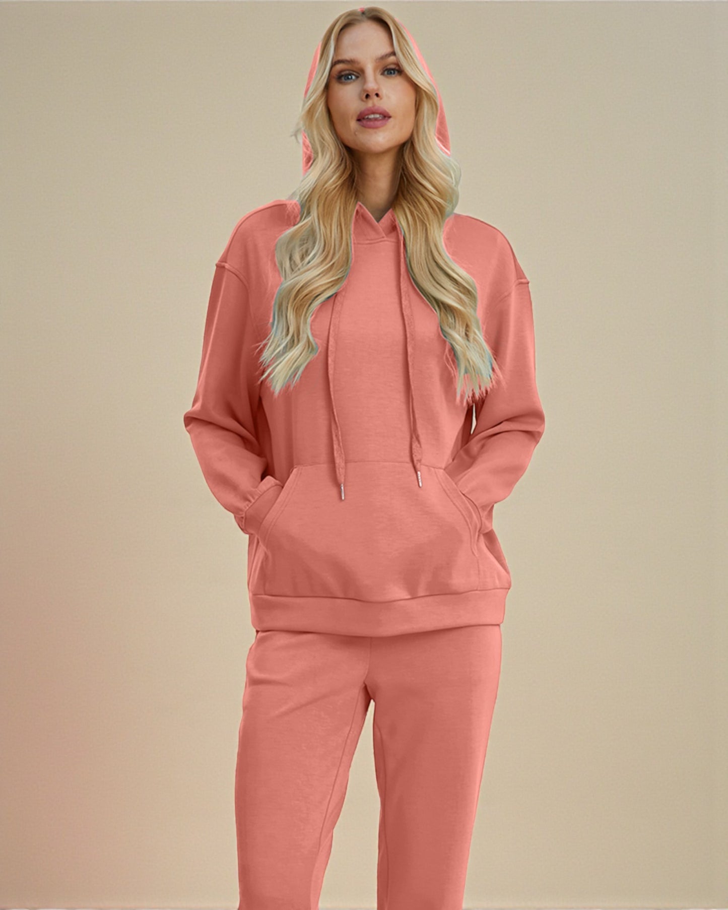 Woman wearing a pink hoodie and pants set on a beige background