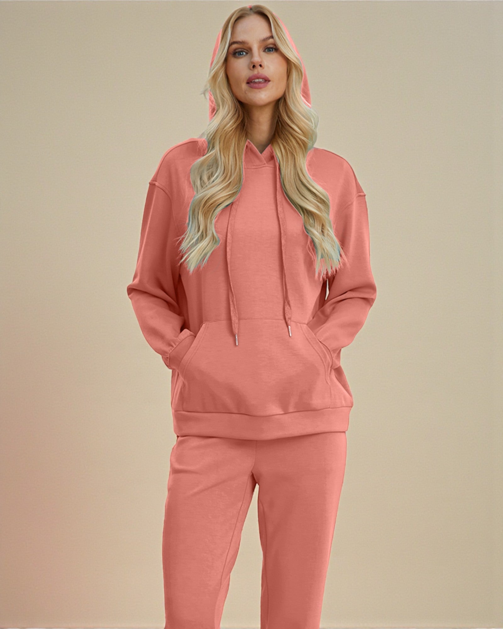 Woman wearing a pink hoodie and pants set on a beige background
